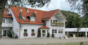 a large white building with an orange roof at Landgasthof Feihl in Oberwiesenacker