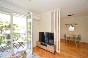 a living room with a television and a table with chairs at The Nest - Urban Family place in Kotor