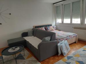 a living room with a couch and a bed at Apartman F&S - Novo Sarajevo in Sarajevo