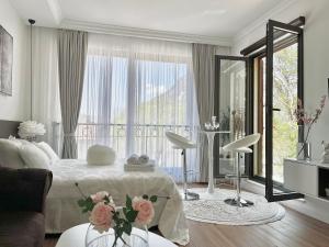 a white bedroom with a bed and a large window at Vacanza, Sea view in Kotor