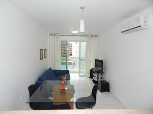 een woonkamer met een blauwe bank en een tafel bij Charmoso e confortável 1 quarto/frente Mar - Mandai / Inicio da praia do Forte - CF07 in Cabo Frio