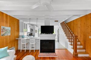 sala de estar y cocina con chimenea y TV en Seaclusion Gardens, en Ocean Beach