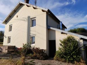 a white house with a garage at La cantinière in Fougerolles