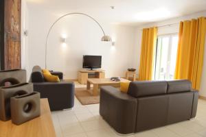 a living room with two couches and a tv at Agua Hotels Sal Vila Verde in Santa Maria