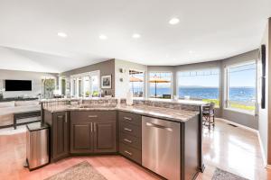 a kitchen with a large island with a view of the ocean at Misty Lady at Water's Edge in Freeland