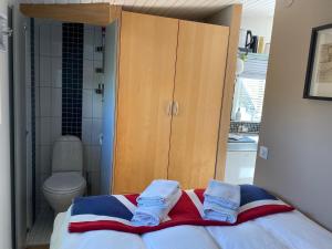 a bedroom with a cabinet and a bed with towels at Eklanda Studio in Gothenburg