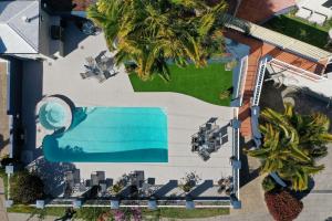 an overhead view of a swimming pool and palm trees at Horizons At Peregian in Peregian Beach