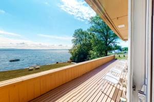 a balcony with chairs and a view of the water at Rockledge in North Hero