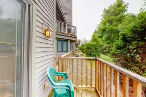 a balcony with a blue chair on a house at Slopeside 705 in Jay