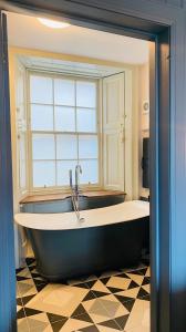 uma grande banheira na casa de banho com uma janela em Custom House Hotel em Bowling
