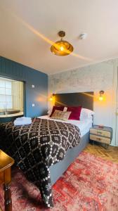 a bedroom with a bed with a black and white comforter at Custom House Hotel in Bowling