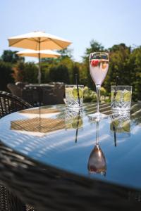a table with three wine glasses on a blue table cloth at Manor House, Alsager in Alsager