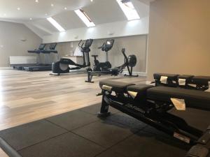 a gym with several tread machines in a room at Manor House Hotel & Spa, Alsager in Alsager