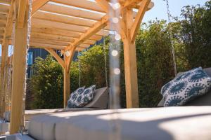 a patio with a wooden pergola and swings at Manor House Hotel & Spa, Alsager in Alsager