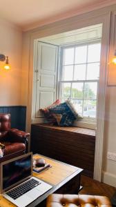 a laptop sitting on a desk in front of a window at Custom House Hotel in Bowling