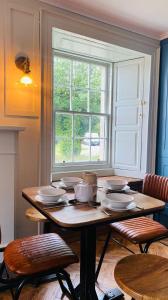 a table with plates on it in front of a window at Custom House Hotel in Bowling