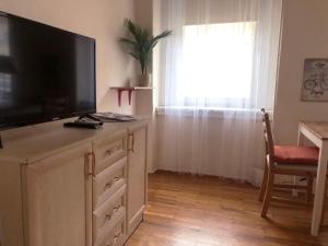 - un salon avec une commode et une télévision à écran plat dans l'établissement V57 APARTMENT OKTOGON, à Budapest