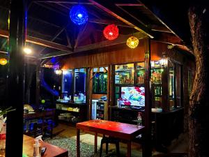 a bar with a table and a television and lights at Pitaya Native Guest House in Panglao Island