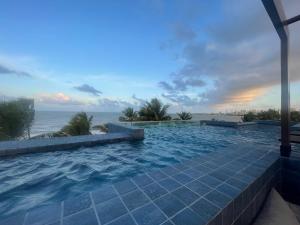 a swimming pool with a view of the ocean at Altamare - Pé na areia in Tambaú