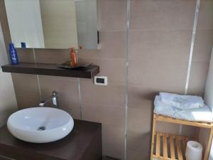 een badkamer met een witte wastafel en een spiegel bij Casa vacanza HADA in San Giacomo degli Schiavoni