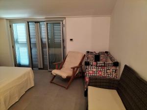 San Giacomo degli SchiavoniにあるCasa vacanza HADAのベッド1台と椅子1脚が備わる客室です。