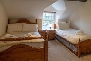 two twin beds in a room with a window at Glasfryn Cottage Dolgellau in Dolgellau