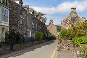 une rue dans un village avec des maisons en pierre dans l'établissement Glasfryn Cottage Dolgellau, à Dolgellau