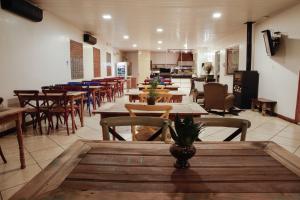 a restaurant with wooden tables and chairs in a room at Rodeio Hotel in Rodeio Bonito