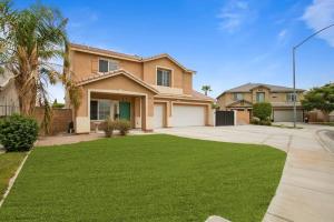 une maison avec une pelouse verte devant elle dans l'établissement Desert Fantasy Oasis Pool, Jacuzzi, Royal Beds, à Coachella