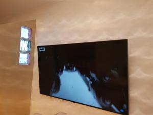 a flat screen tv on a wall with a window at Los BOLICHES Playa in Fuengirola