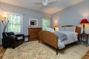 1 dormitorio con 1 cama, 1 silla y ventanas en The Hidden Gem, en Weaverville
