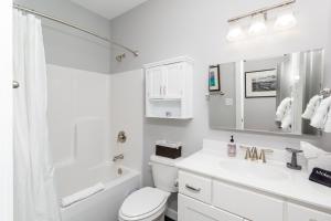 Baño blanco con lavabo y espejo en The Hidden Gem, en Weaverville