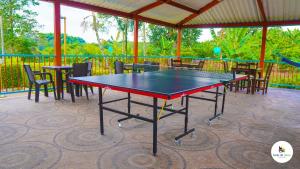 una mesa de ping pong en un patio con mesas y sillas en Finca Hotel Monte del Libano, en Montenegro