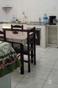 a kitchen with a table and chairs in a kitchen at Aconchego Sagrada Face in Aparecida