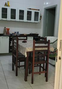 a kitchen with a table and chairs in a room at Aconchego Sagrada Face in Aparecida