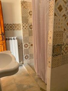 Cerreto di SpoletoにあるResidence il giardino sul fiume Neraのシャワーカーテンと洗面台付きのバスルーム