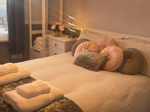 una camera da letto con un letto con cuscini sopra di Courtyard Holiday Apartments a Belper