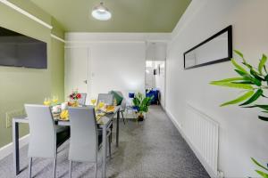 - une salle à manger avec une table et des chaises dans l'établissement Cheerful 2 Bedroom Home, Sleeps 5 Guest Comfy, 1x Double Bed, 3x Single Beds, Free Parking, Free WiFi, Suitable For Business, Leisure Guest,Coventry, Midlands, à Coventry