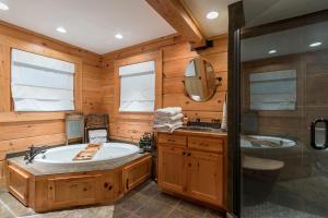 uma casa de banho com uma banheira, um lavatório e um chuveiro em Whispering Pines em Sapphire