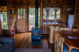 una estufa en el medio de una cocina en una cabaña de madera en Mallin Colorado Ecolodge, en Aldana