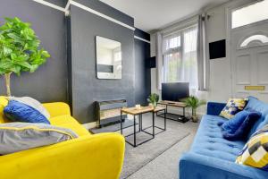 uma sala de estar com mobiliário azul e amarelo e uma televisão em Cheerful 2 Bedroom Home, Sleeps 5 Guest Comfy, 1x Double Bed, 3x Single Beds, Free Parking, Free WiFi, Suitable For Business, Leisure Guest,Coventry, Midlands em Coventry