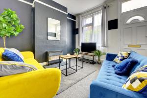 uma sala de estar com mobiliário azul e amarelo e uma televisão em Cheerful 2 Bedroom Home, Sleeps 5 Guest Comfy, 1x Double Bed, 3x Single Beds, Free Parking, Free WiFi, Suitable For Business, Leisure Guest,Coventry, Midlands em Coventry