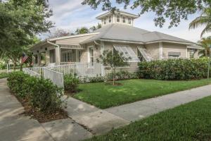a white house with a porch and a tree at Greenlinks-Lely-Building 1200 in Lely Resort
