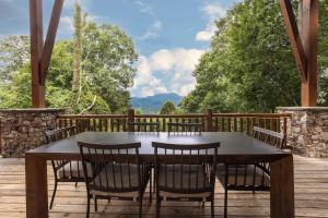 a table and chairs on a deck with a view at Bear Vista Trail in Waynesville