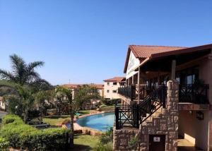 a house with a swimming pool next to a building at Ocean View Villas F05 in Port Edward