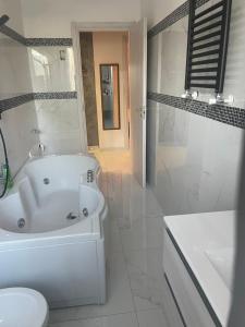 ein weißes Badezimmer mit einer Badewanne, einem WC und einem Waschbecken in der Unterkunft Appartamento Mire&Geo in Voghera