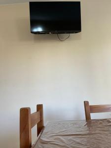 TV de pantalla plana colgada en una pared blanca en Fuente de vida en Colón
