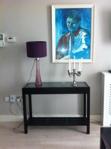 a table with a lamp and a painting on the wall at Beautiful apartment central location in Dublin