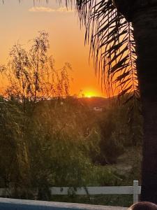 a sunset seen through a window with a fence at Yurt Escape with Amazing Country Views in Temecula