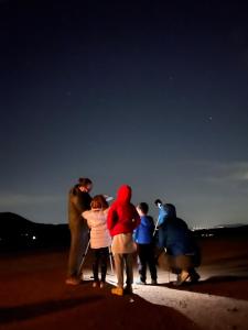 un grupo de personas de pie en una playa por la noche en Yurt Escape with Amazing Country Views, en Temecula